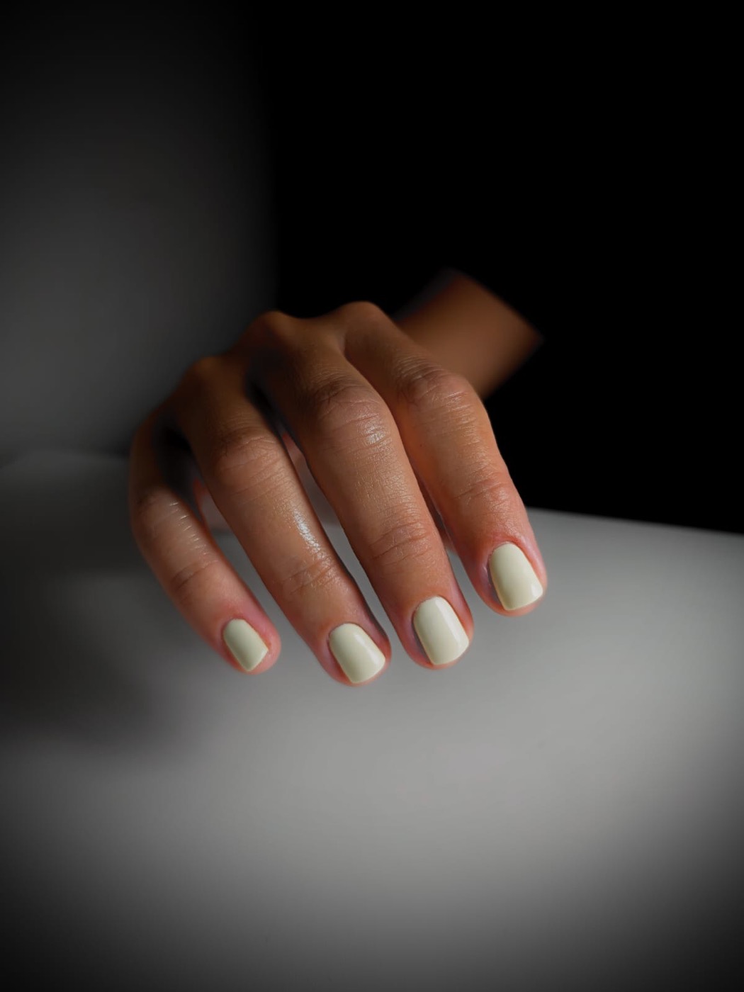 Short square nails in a soft cream shellac